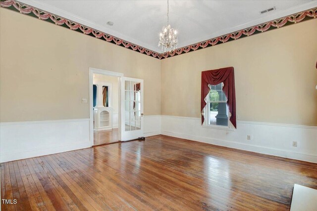 125 W Pine St, Pine Level, NC 27568 - empty room with a chandelier, hardwood / wood-style flooring, wainscoting, crown molding, and french doors