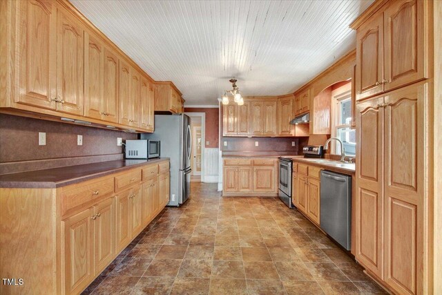 125 W Pine St, Pine Level, NC 27568 - kitchen with appliances with stainless steel finishes, under cabinet range hood, light brown cabinetry, a sink, and a chandelier