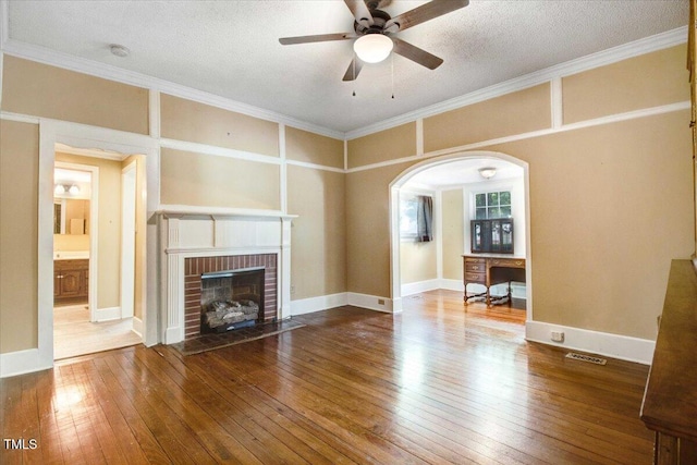 125 W Pine St, Pine Level, NC 27568 - unfurnished living room with hardwood / wood-style floors, ceiling fan, a brick fireplace, arched walkways, and crown molding