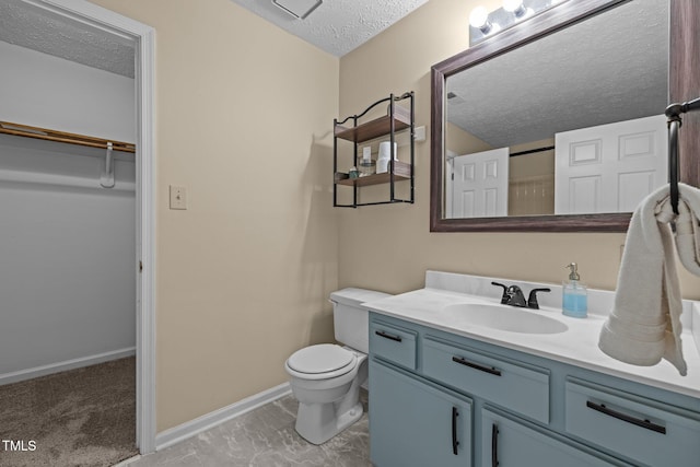 5801 Hadrian Dr, Durham, NC 27703 - bathroom featuring a textured ceiling, vanity, and a spacious closet