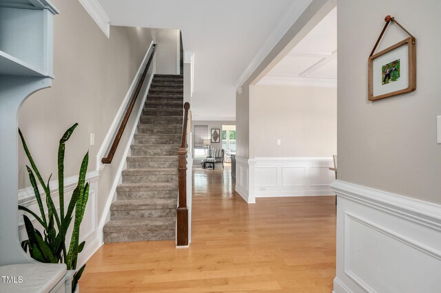 5637 Garnet Meadow Rd, Knightdale, NC 27545 - staircase featuring wood finished floors, a wainscoted wall, ornamental molding, and a decorative wall