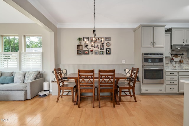 5637 Garnet Meadow Rd, Knightdale, NC 27545 - dining area featuring light wood-style floors, a chandelier, wainscoting, and crown molding