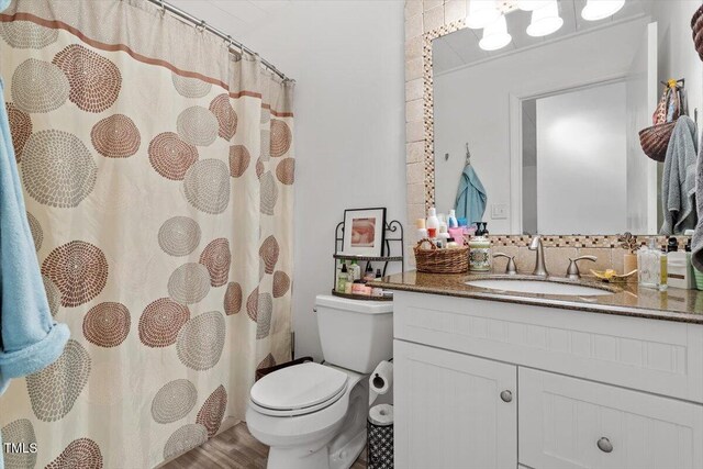 1009 Iredell St Unit D, Durham, NC 27705 - full bath with vanity, wood finished floors, decorative backsplash, and a shower with curtain