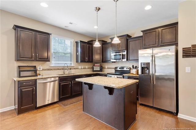 18 Hallow Oak St, Spring Lake, NC 28390 - kitchen with stainless steel appliances, a sink, dark brown cabinetry, backsplash, and light wood-style floors