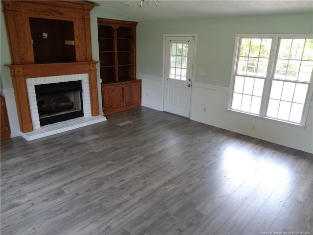 711 Fairview St, Fayetteville, NC 28312 - unfurnished living room featuring a brick fireplace, wood finished floors, and wainscoting