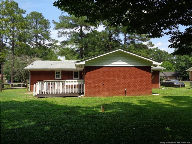 711 Fairview St, Fayetteville, NC 28312 - back of property with a lawn, a deck, and brick siding