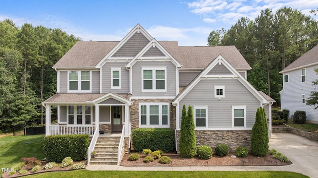 7410 Chouder Ln, Wake Forest, NC 27587 - craftsman-style house featuring stone siding, covered porch, stairway, and roof with shingles