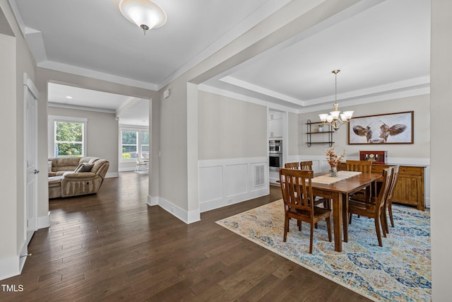 7410 Chouder Ln, Wake Forest, NC 27587 - dining area featuring a raised ceiling, dark wood-type flooring, a chandelier, a wainscoted wall, and ornamental molding