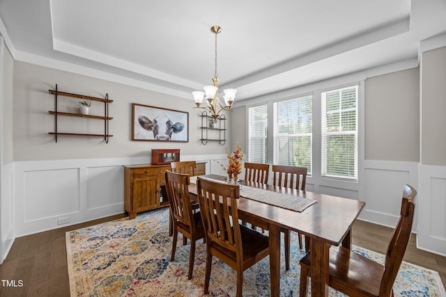 7410 Chouder Ln, Wake Forest, NC 27587 - dining area with a tray ceiling, a wainscoted wall, a decorative wall, a chandelier, and wood finished floors