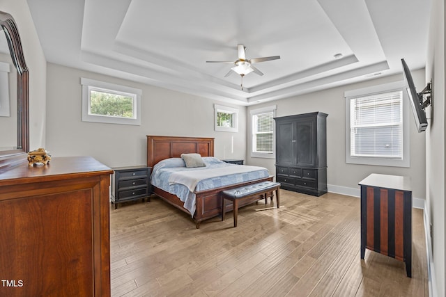 7410 Chouder Ln, Wake Forest, NC 27587 - bedroom with a tray ceiling, light wood finished floors, multiple windows, and ceiling fan
