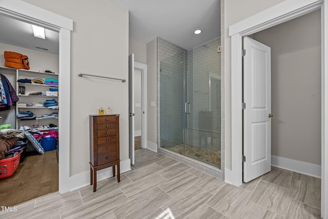 7410 Chouder Ln, Wake Forest, NC 27587 - bathroom with a stall shower, a spacious closet, and wood finished floors