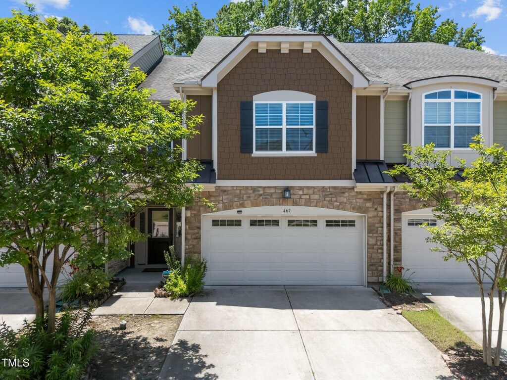 469 Methven Grove Dr, Cary, NC 27519 - view of property with an attached garage, stone siding, concrete driveway, and roof with shingles