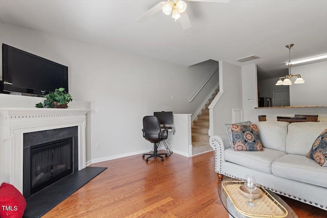 1109 Hadel Pl, Knightdale, NC 27545 - living room with ceiling fan, wood finished floors, stairs, and a fireplace with raised hearth