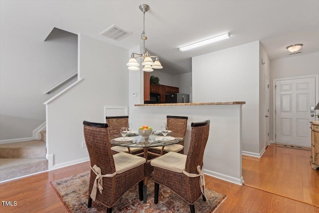 1109 Hadel Pl, Knightdale, NC 27545 - dining space with a chandelier, light wood-style floors, and stairway
