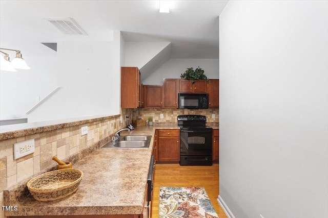 1109 Hadel Pl, Knightdale, NC 27545 - kitchen with black appliances, tasteful backsplash, light countertops, and brown cabinets