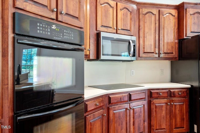 8415 Meadow View Ln, Bahama, NC 27503 - kitchen with black appliances, light countertops, and brown cabinetry