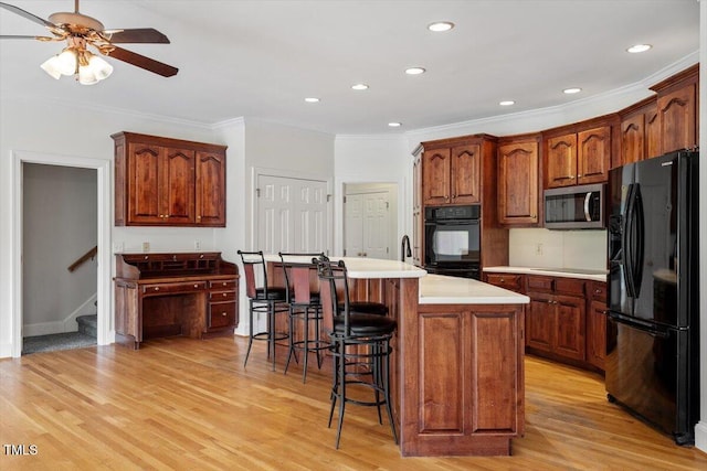 8415 Meadow View Ln, Bahama, NC 27503 - kitchen featuring black appliances, ornamental molding, a ceiling fan, light countertops, and a kitchen breakfast bar