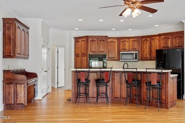 8415 Meadow View Ln, Bahama, NC 27503 - kitchen featuring black appliances, light wood finished floors, a ceiling fan, a kitchen bar, and recessed lighting