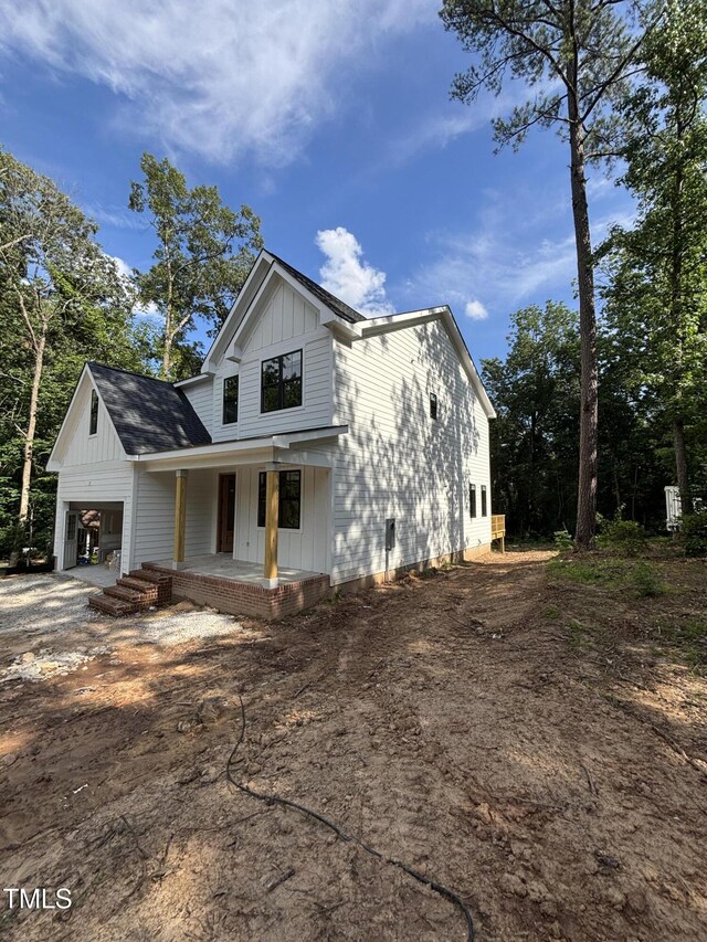 4035 King Charles Rd, Durham, NC 27707 - view of front of house with board and batten siding, covered porch, and driveway
