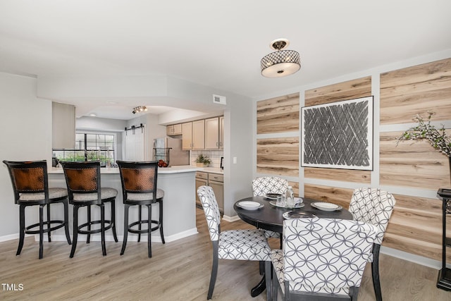 7708 Falcon Rest Cir, Raleigh, NC 27615 - dining room with a barn door and light wood-style flooring