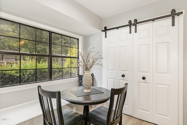 7708 Falcon Rest Cir, Raleigh, NC 27615 - dining room with a barn door and light wood-style flooring