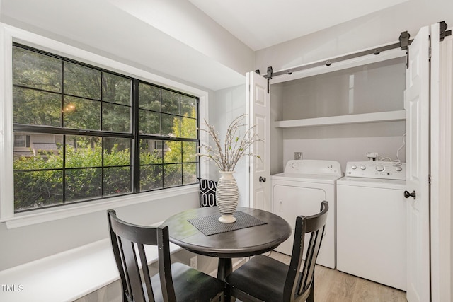 7708 Falcon Rest Cir, Raleigh, NC 27615 - dining room with a barn door, washing machine and dryer, and light wood-type flooring