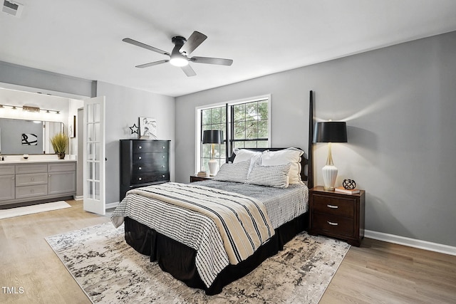 7708 Falcon Rest Cir, Raleigh, NC 27615 - bedroom featuring light wood-style floors, ensuite bath, and a ceiling fan