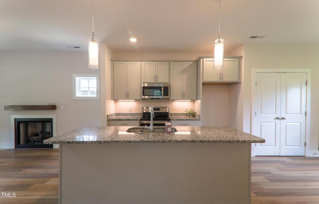 202 E S St, Fremont, NC 27830 - kitchen with appliances with stainless steel finishes, light stone countertops, wood finished floors, recessed lighting, and pendant lighting