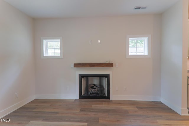 202 E S St, Fremont, NC 27830 - unfurnished living room featuring healthy amount of natural light, wood finished floors, and a fireplace