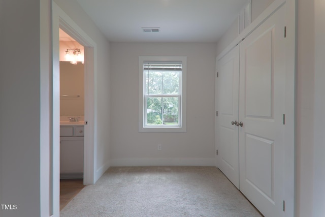 202 E S St, Fremont, NC 27830 - unfurnished bedroom with connected bathroom, light carpet, and a closet