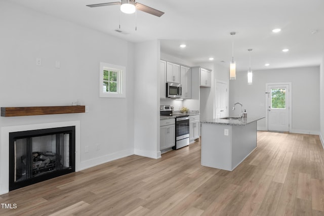 202 E S St, Fremont, NC 27830 - kitchen featuring appliances with stainless steel finishes, light wood-type flooring, a ceiling fan, recessed lighting, and light stone counters