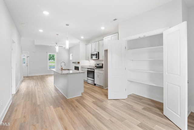 202 E S St, Fremont, NC 27830 - kitchen featuring stainless steel appliances, light wood-style floors, a center island with sink, recessed lighting, and white cabinets