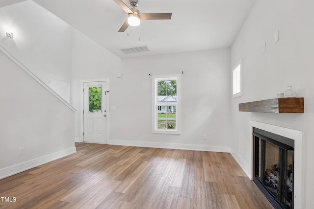 202 E S St, Fremont, NC 27830 - unfurnished living room with light wood-type flooring, a fireplace, and a ceiling fan