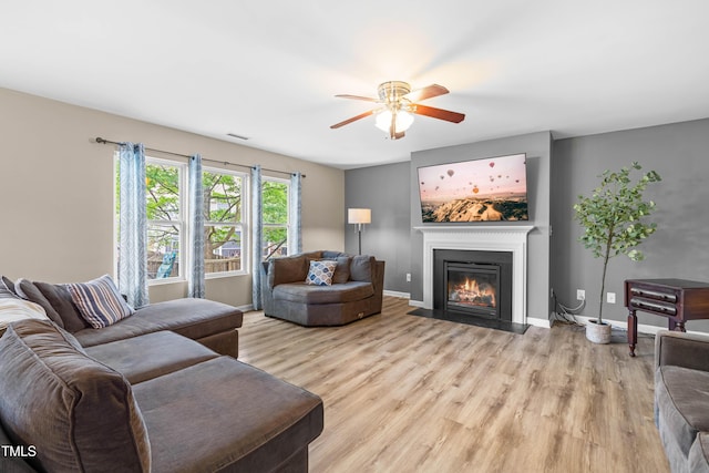 2011 Unbridled Dr, Knightdale, NC 27545 - living room with a fireplace with flush hearth, light wood-style floors, a ceiling fan, and baseboards