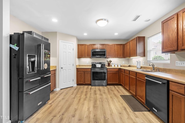 2011 Unbridled Dr, Knightdale, NC 27545 - kitchen featuring stainless steel appliances, a sink, light wood-style floors, light countertops, and recessed lighting