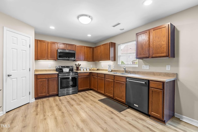 2011 Unbridled Dr, Knightdale, NC 27545 - kitchen featuring stainless steel appliances, a sink, light wood finished floors, light countertops, and brown cabinetry