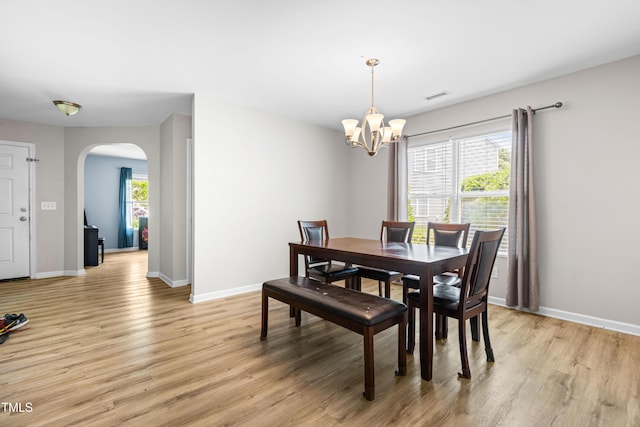 2011 Unbridled Dr, Knightdale, NC 27545 - dining area featuring arched walkways, light wood-style floors, a chandelier, and baseboards