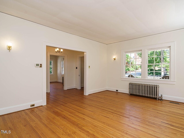 907 W Johnson St, Raleigh, NC 27605 - spare room featuring radiator, a chandelier, and light wood finished floors