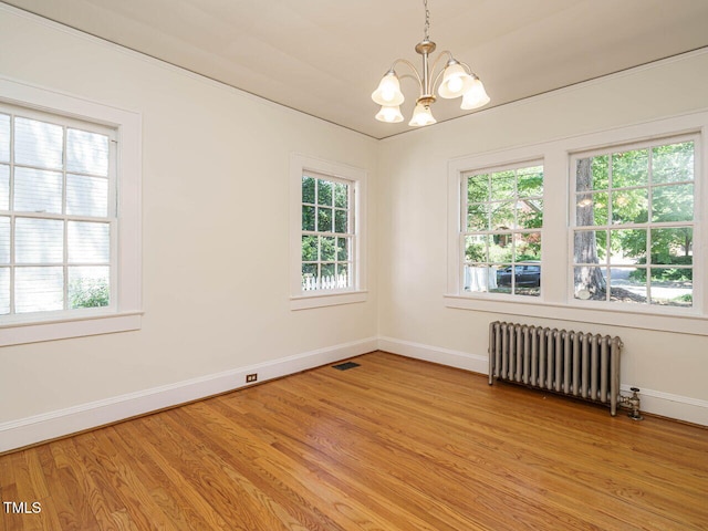 907 W Johnson St, Raleigh, NC 27605 - spare room featuring radiator, a chandelier, healthy amount of natural light, and light wood-type flooring