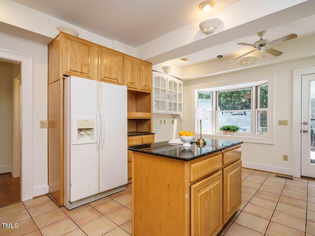907 W Johnson St, Raleigh, NC 27605 - kitchen with white fridge with ice dispenser, light tile patterned floors, a kitchen island, and dark stone countertops