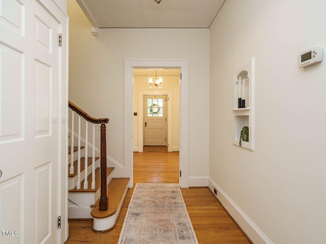 907 W Johnson St, Raleigh, NC 27605 - hall with light wood-style flooring, a chandelier, stairway, and ornamental molding