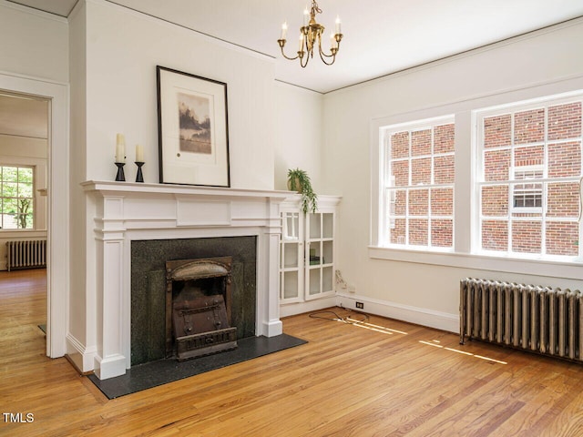 907 W Johnson St, Raleigh, NC 27605 - living room with radiator heating unit, wood finished floors, a chandelier, and ornamental molding