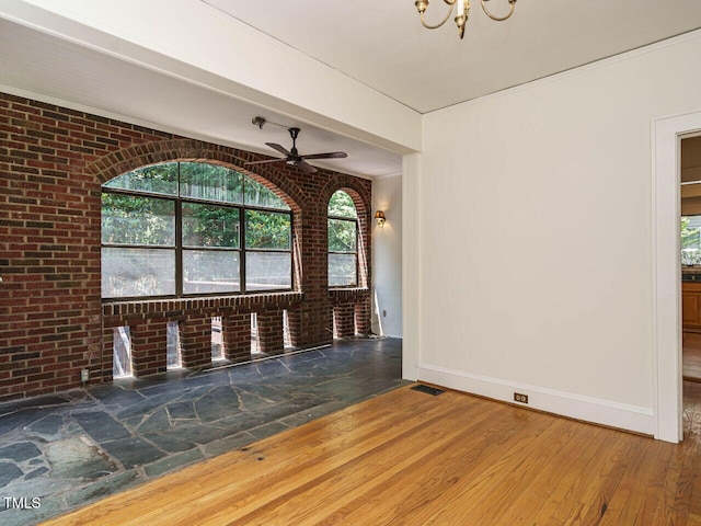 907 W Johnson St, Raleigh, NC 27605 - unfurnished dining area with brick wall, wood finished floors, ceiling fan, and a chandelier