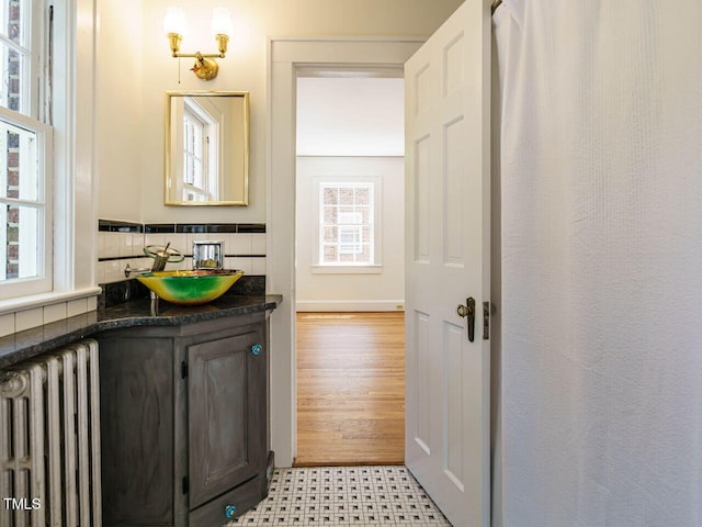 907 W Johnson St, Raleigh, NC 27605 - bathroom with radiator heating unit, vanity, and decorative backsplash