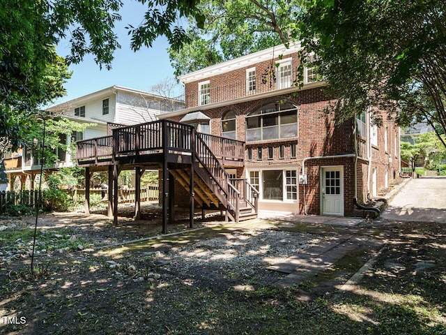907 W Johnson St, Raleigh, NC 27605 - rear view of house with brick siding, a wooden deck, and stairs
