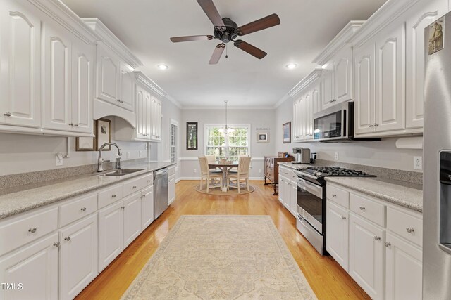 102 Sevendales Dr, Goldsboro, NC 27534 - kitchen with appliances with stainless steel finishes, a sink, light wood-type flooring, white cabinetry, and recessed lighting
