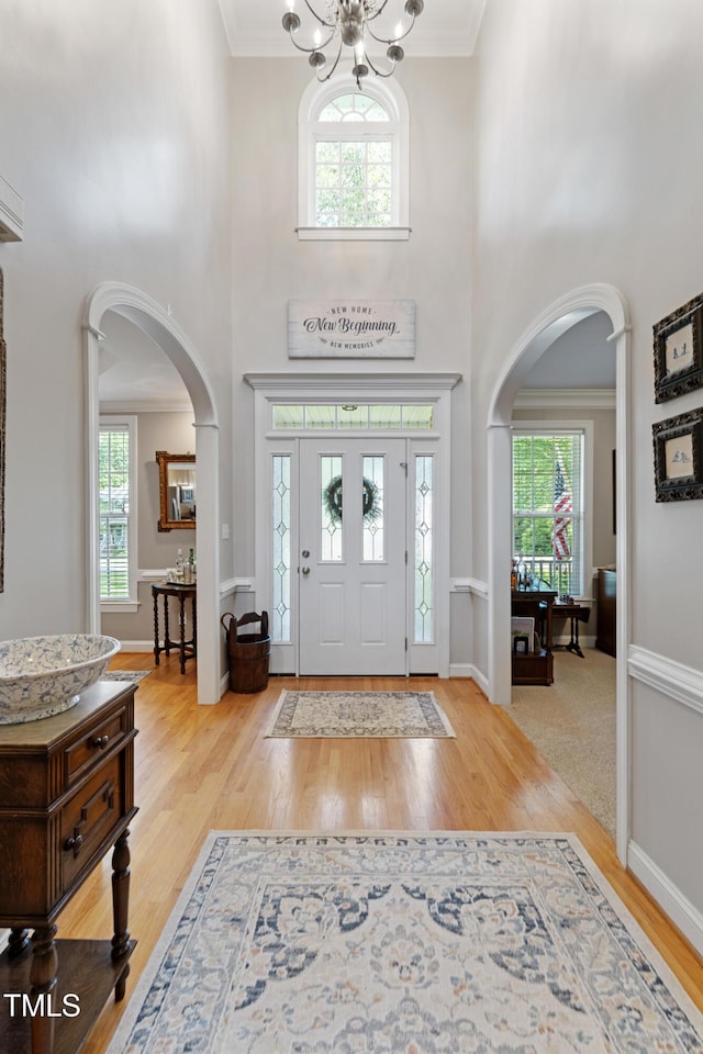 102 Sevendales Dr, Goldsboro, NC 27534 - foyer with arched walkways, a high ceiling, wood finished floors, a chandelier, and baseboards