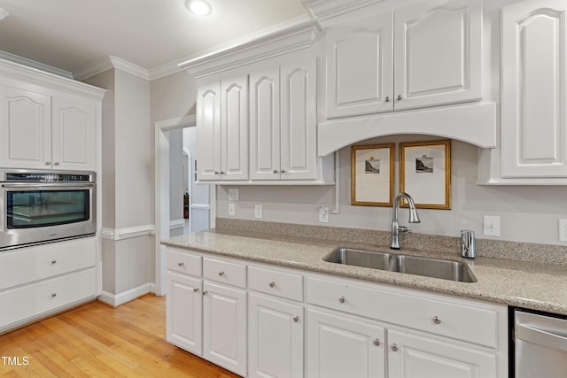 102 Sevendales Dr, Goldsboro, NC 27534 - kitchen featuring stainless steel appliances, a sink, ornamental molding, white cabinetry, and light wood-style flooring