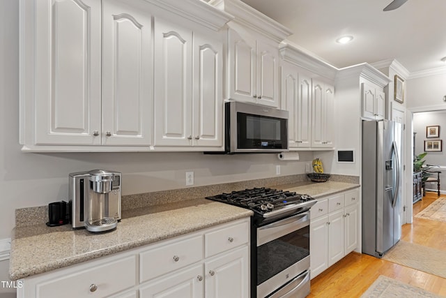 102 Sevendales Dr, Goldsboro, NC 27534 - kitchen featuring appliances with stainless steel finishes, light wood finished floors, white cabinetry, ornamental molding, and recessed lighting