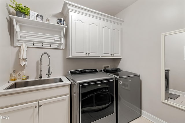 102 Sevendales Dr, Goldsboro, NC 27534 - laundry room with washing machine and clothes dryer, cabinet space, light tile patterned floors, and baseboards